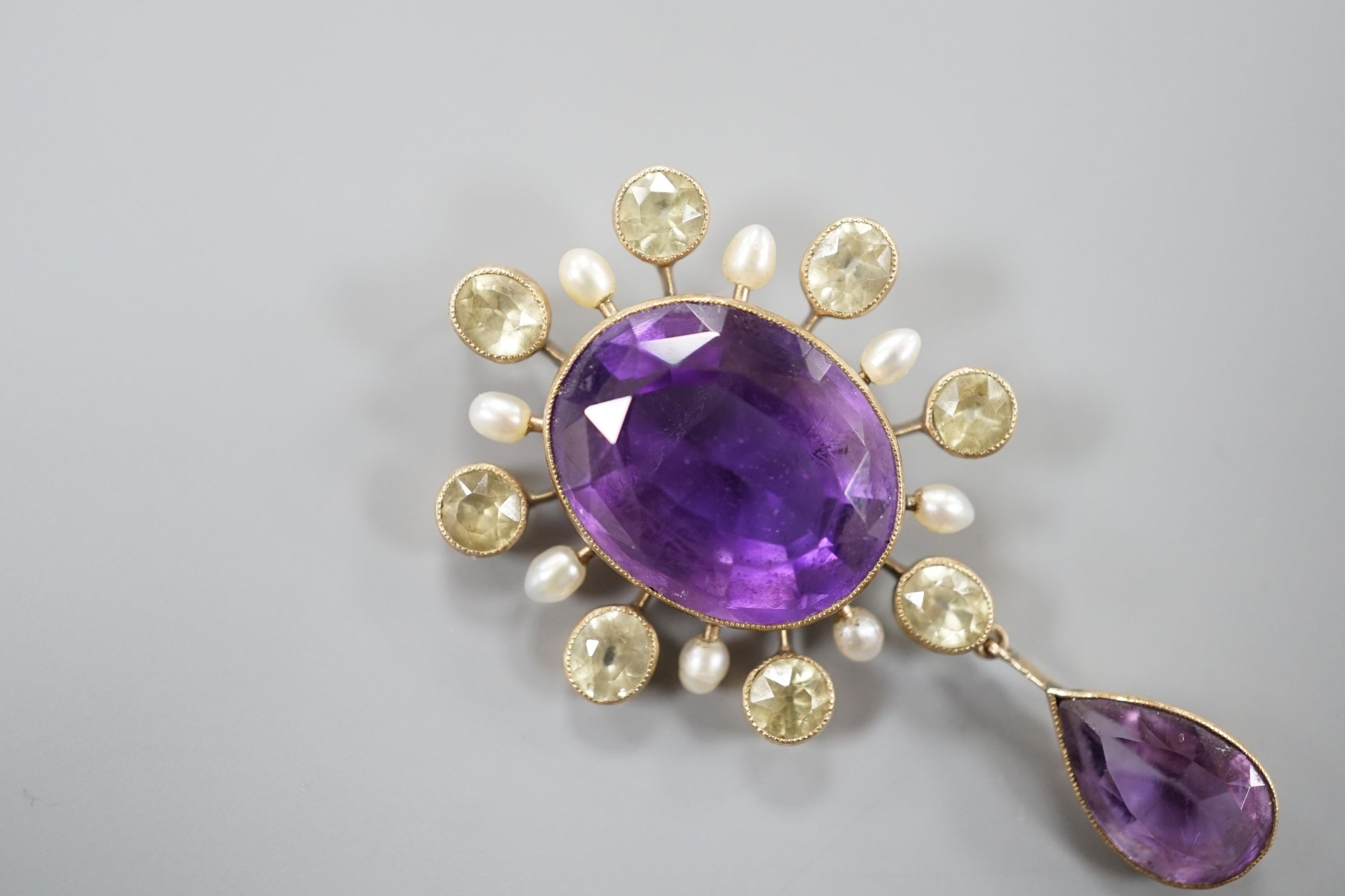 An early 20th century yellow metal, amethyst, olivine, and baroque pearl set drop pendant, 47mm, gross weight 5.4 grams.
